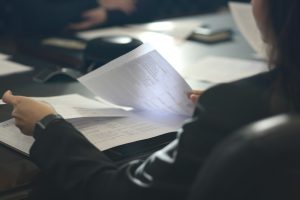 O persoană citește un document la birou