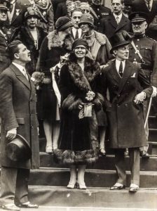 Regina Maria într-o fotografie istorică, înconjurată de persoane, în timpul turneului nord-american din 1926
