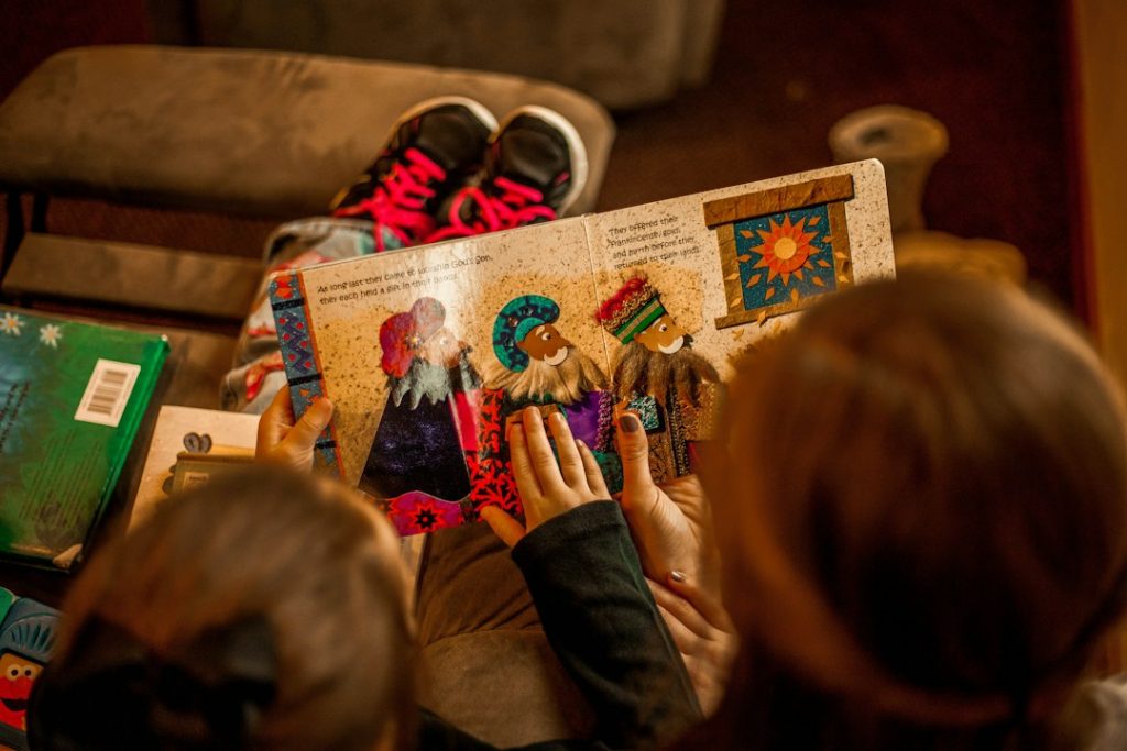 Doi copii citind o carte pe o canapea, imagine de arhivă care nu reprezintă evenimentul de la Madrid